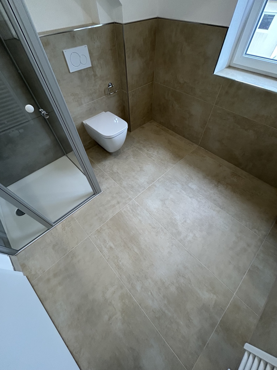 Badezimmer mit großformatigen Bodenfliesen und Dusche