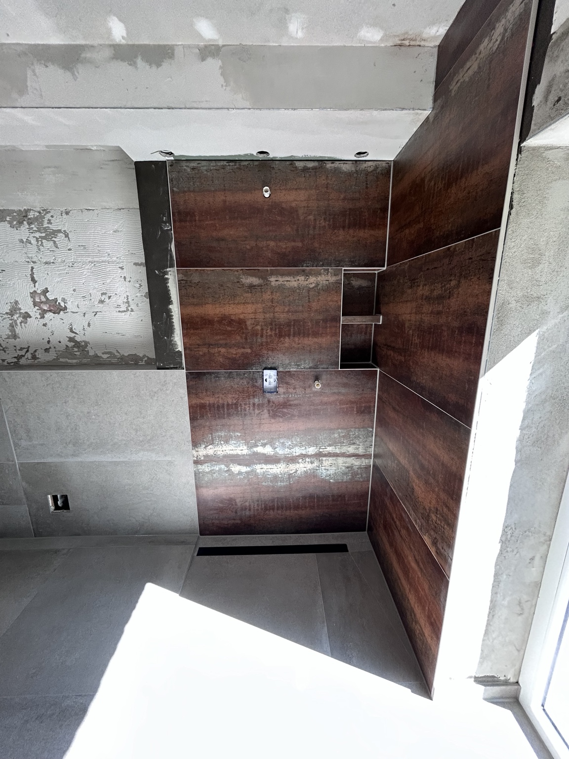 Badezimmer in der Bauphase mit Akzentwand und integrierten Ablagen