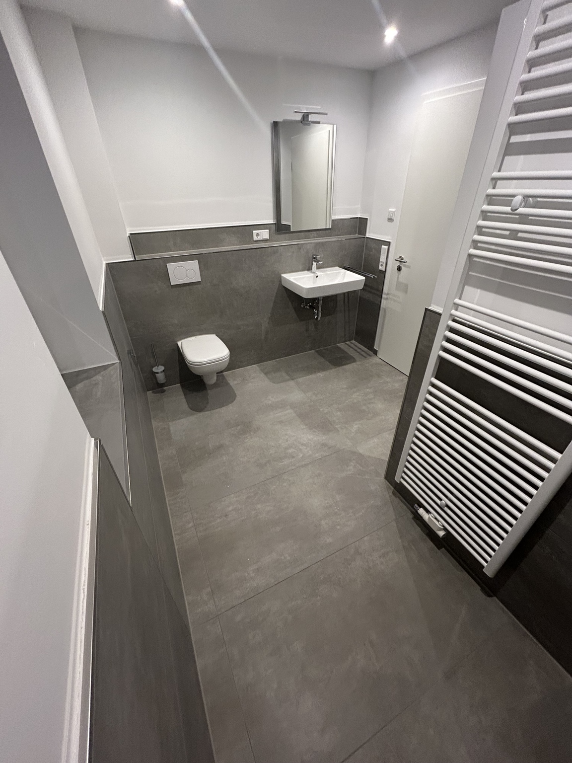 Modernes Badezimmer mit großformatigen grauen Boden- und Wandfliesen
