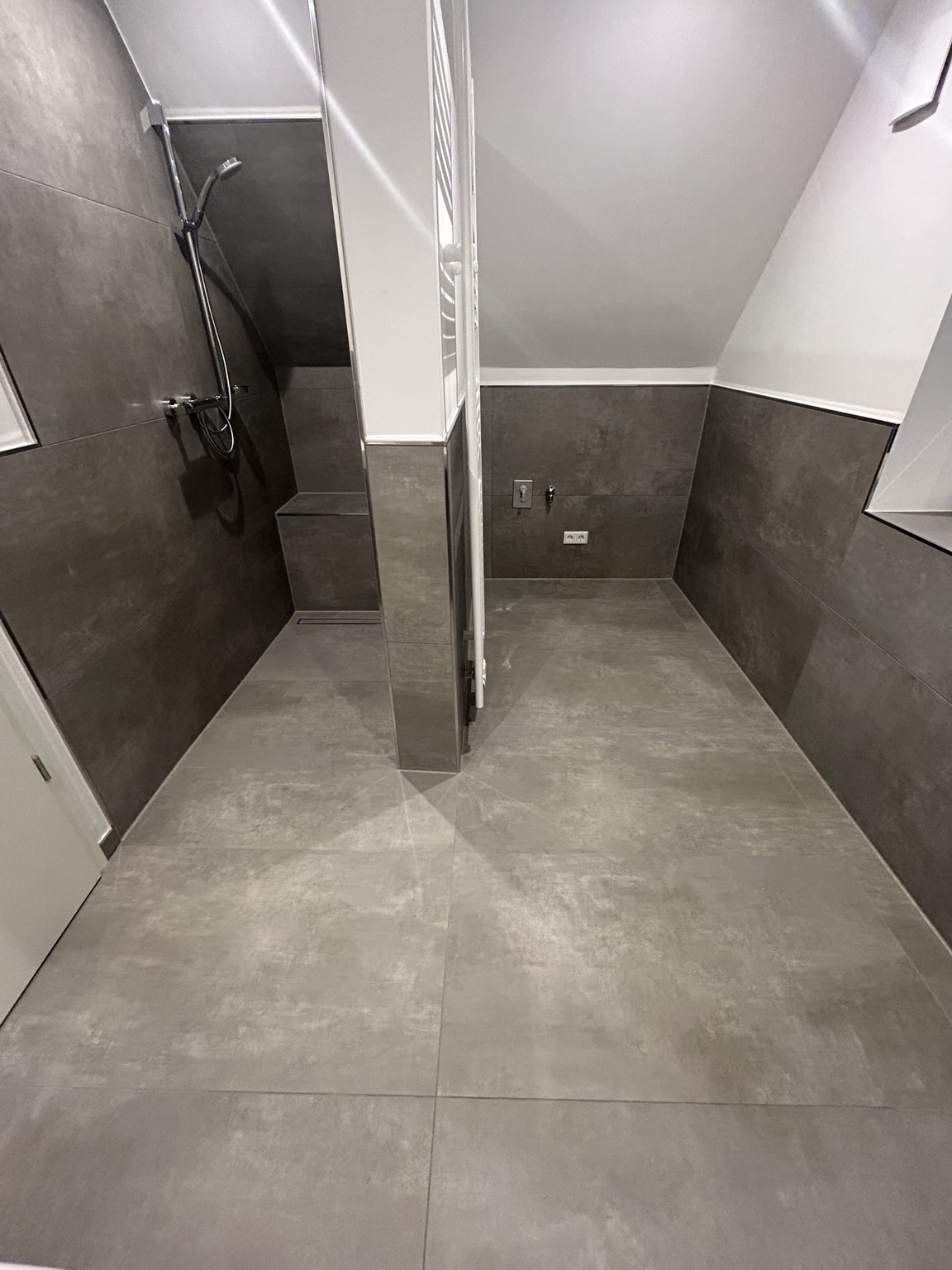 Großformatig gefliester Badbereich mit Dusche