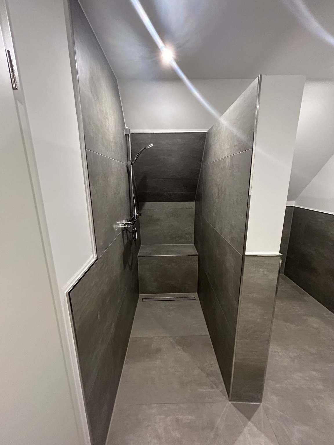 Bodengleiche Dusche mit Sitzbank und großformatigen Fliesen