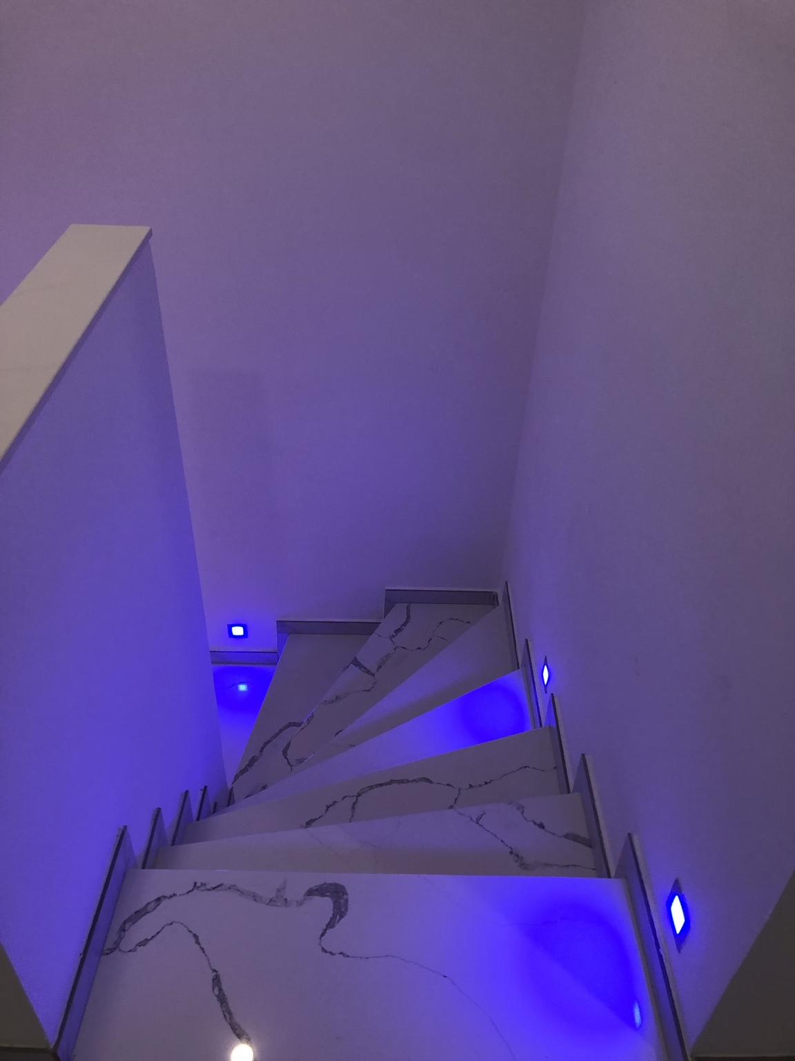 Beleuchtete Treppe mit großformatiger Marmoroptik
